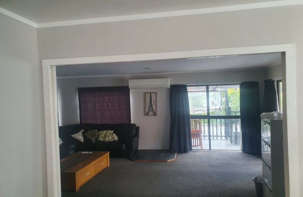 Living room with couch, coffee table, and sliding glass doors opening to a balcony