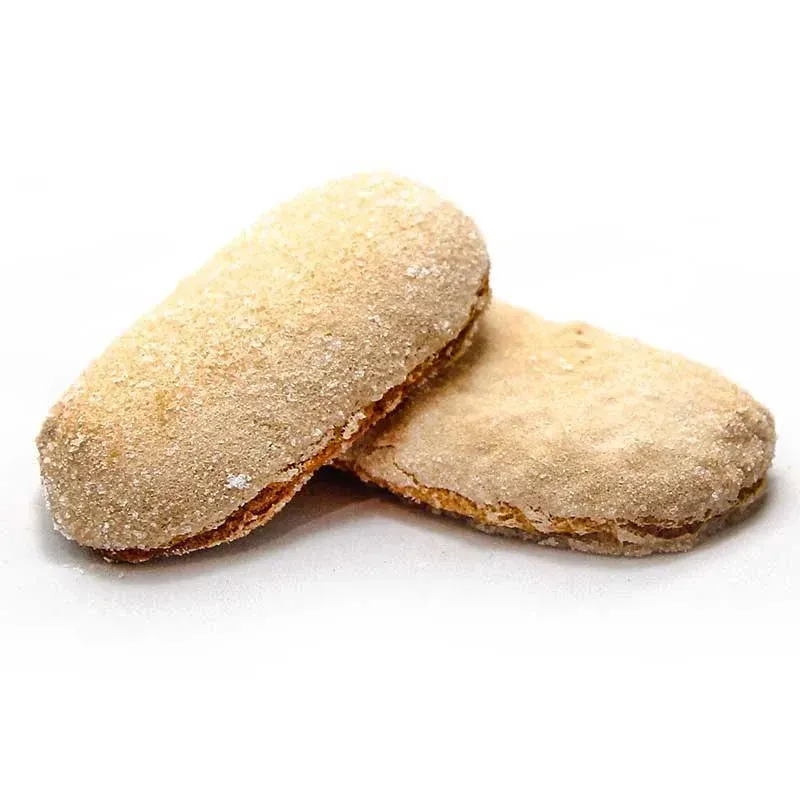 Due biscotti sono appoggiati uno sopra l'altro su una superficie bianca.