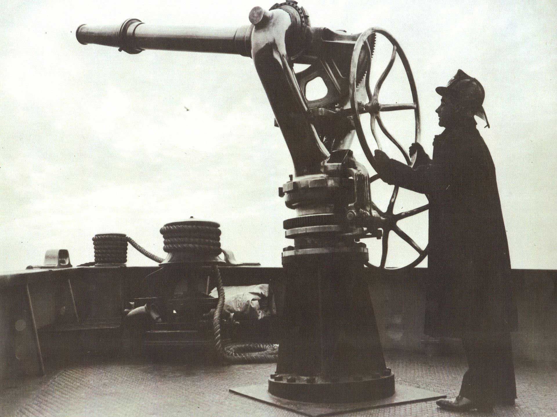 A person operating a large telescope on a ship deck.