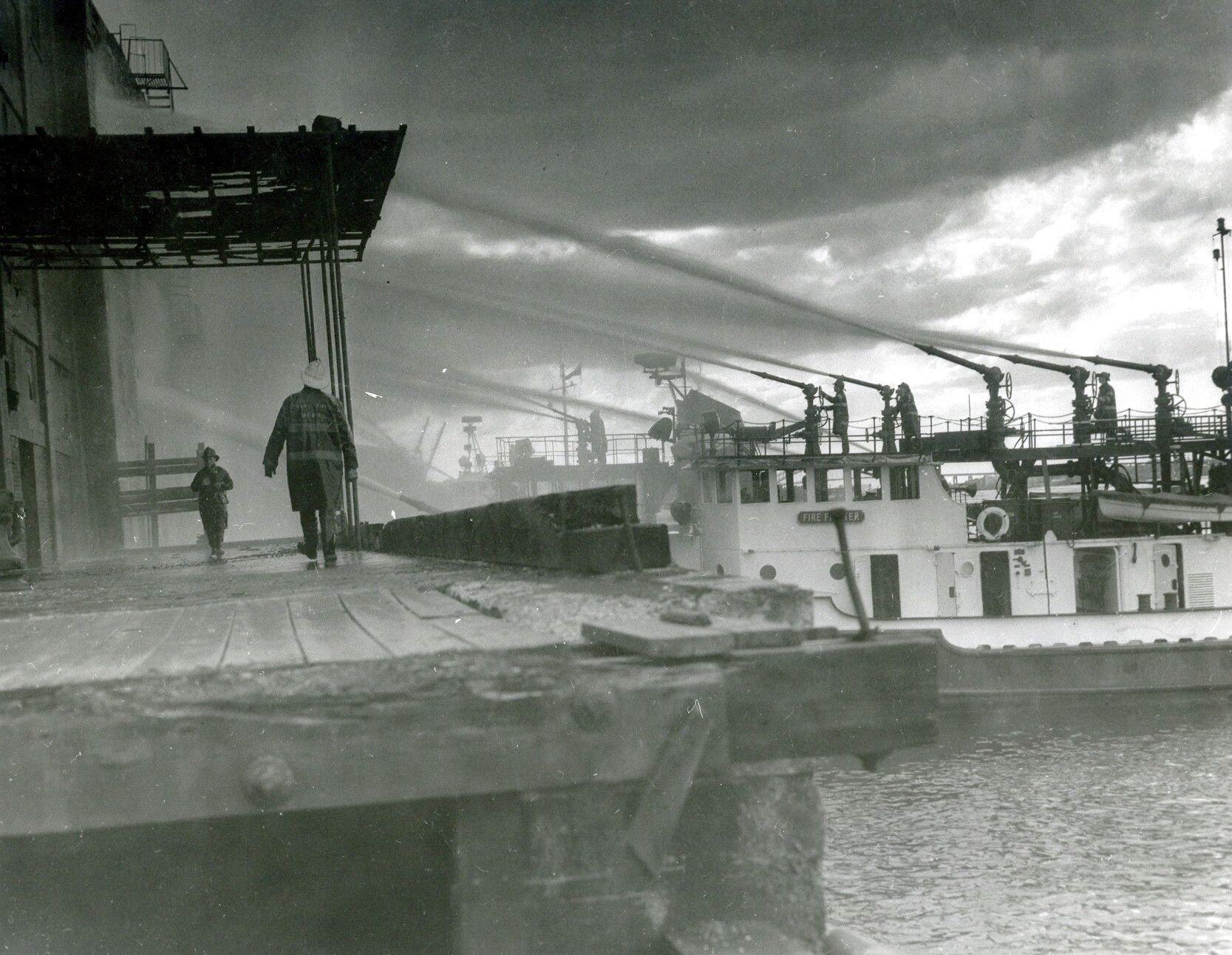Fireboat spraying water in the ocean; red and white with multiple water cannons. Fireboat spraying water in the ocean; red and white with multiple water cannons.