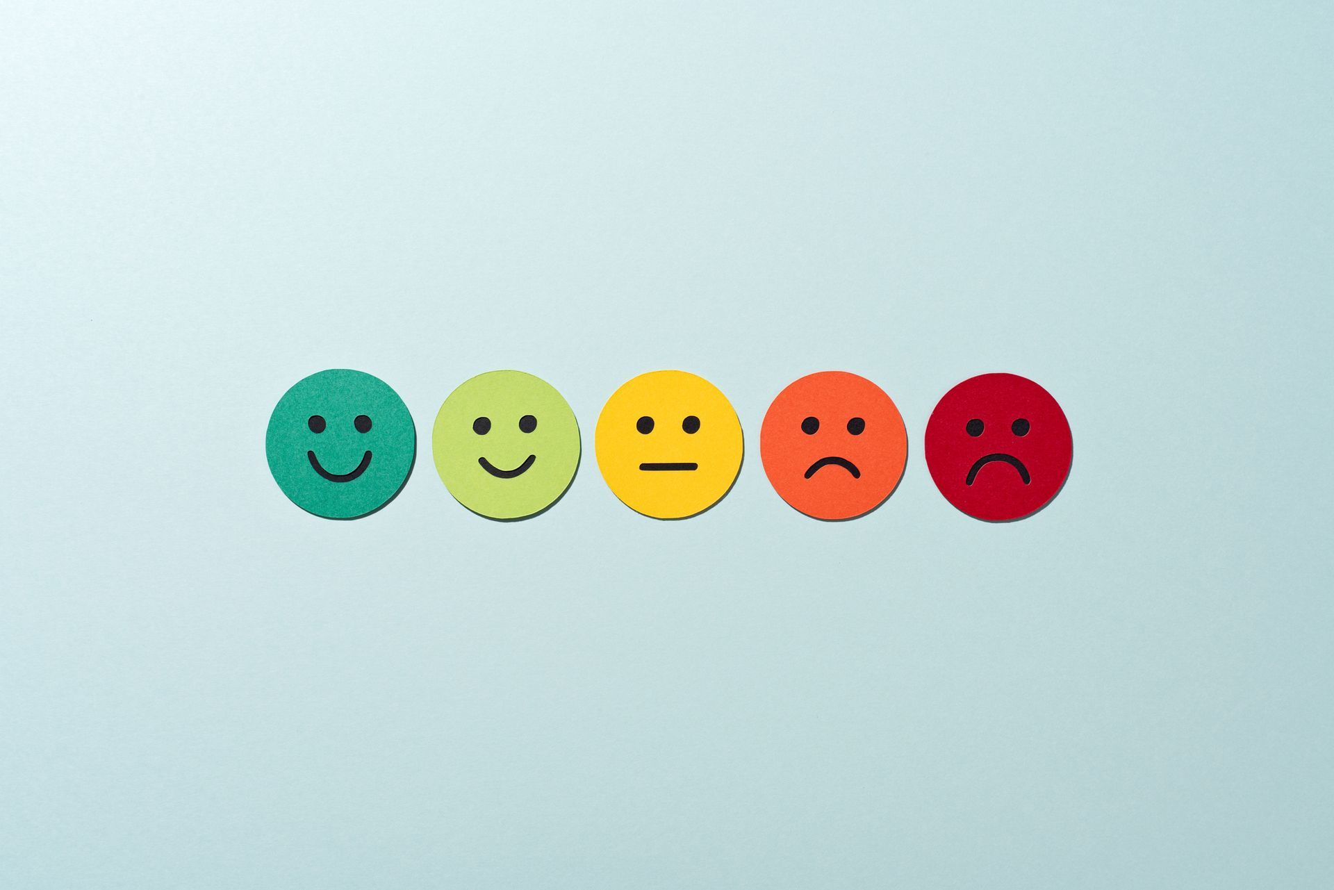 A row of smiley faces in different colors on a blue background.