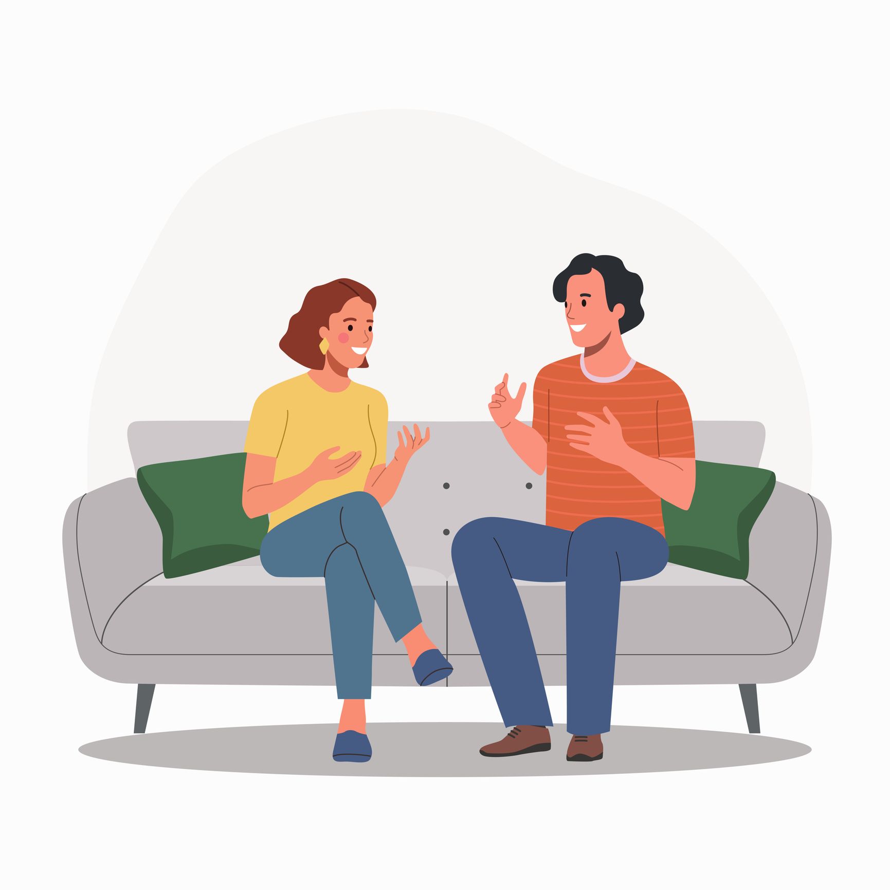 A man and a woman are sitting on a couch talking to each other.