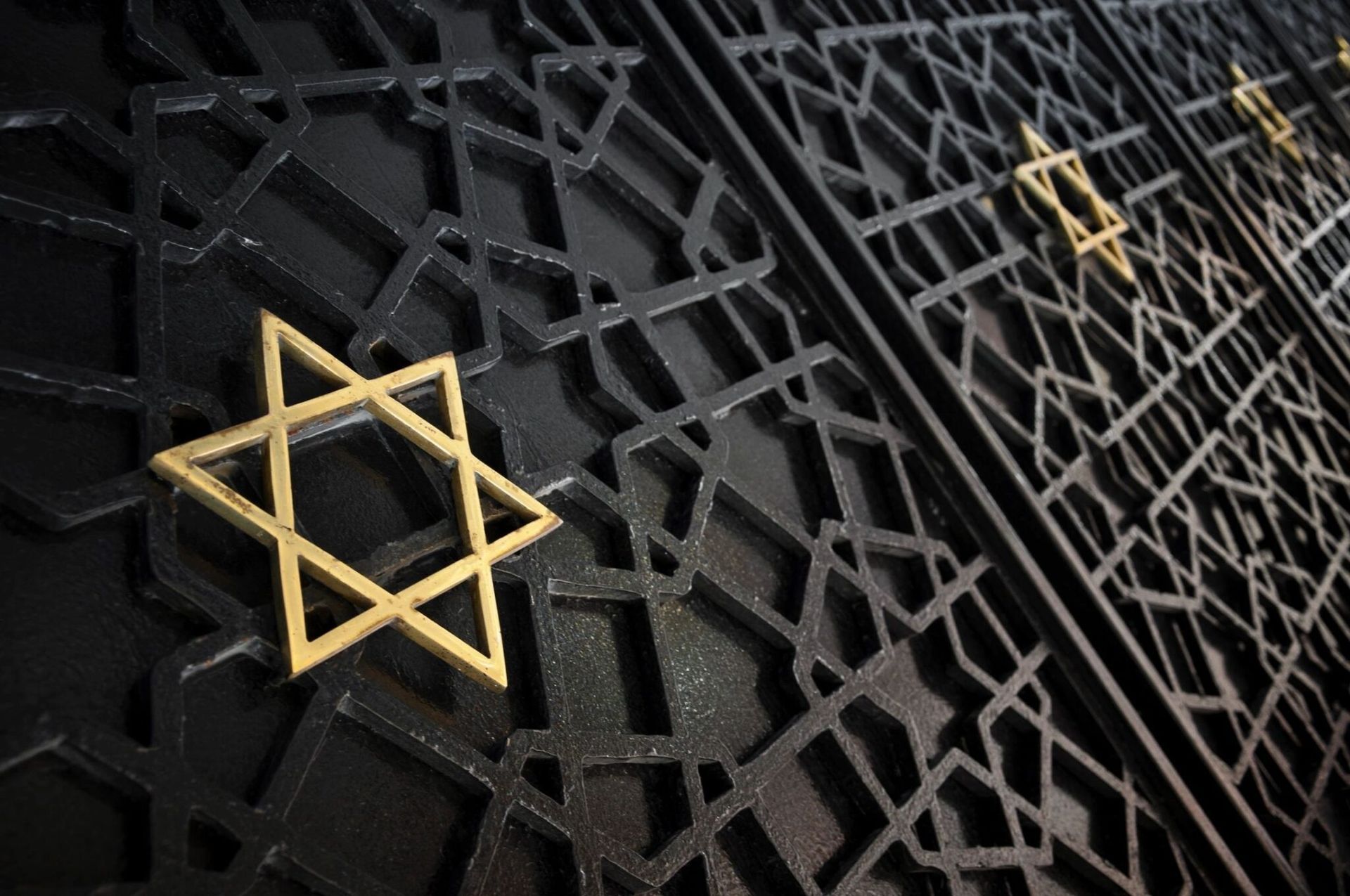 Black metal gates with gold Star of David symbols.