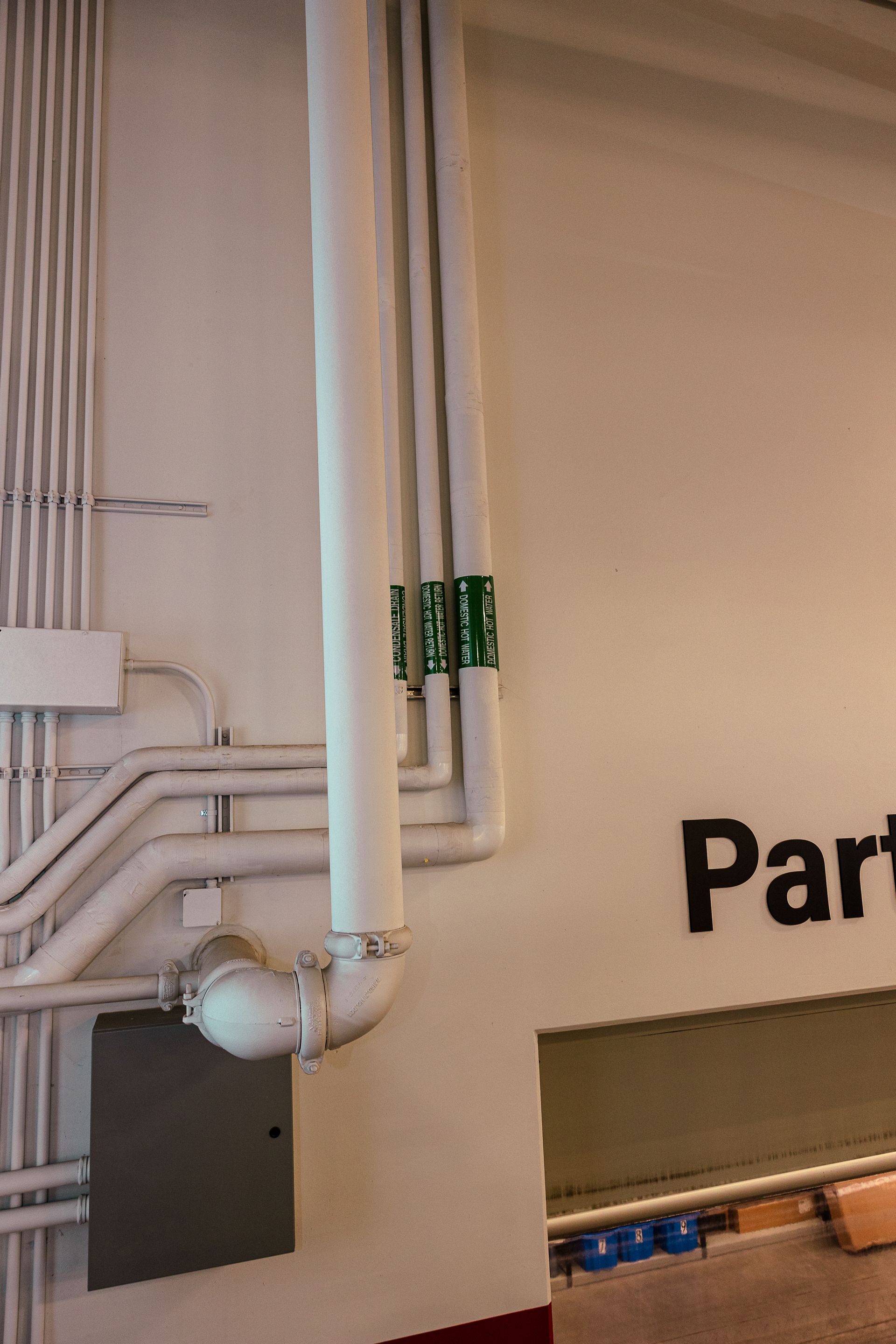 A wall with pipes and the word part on it