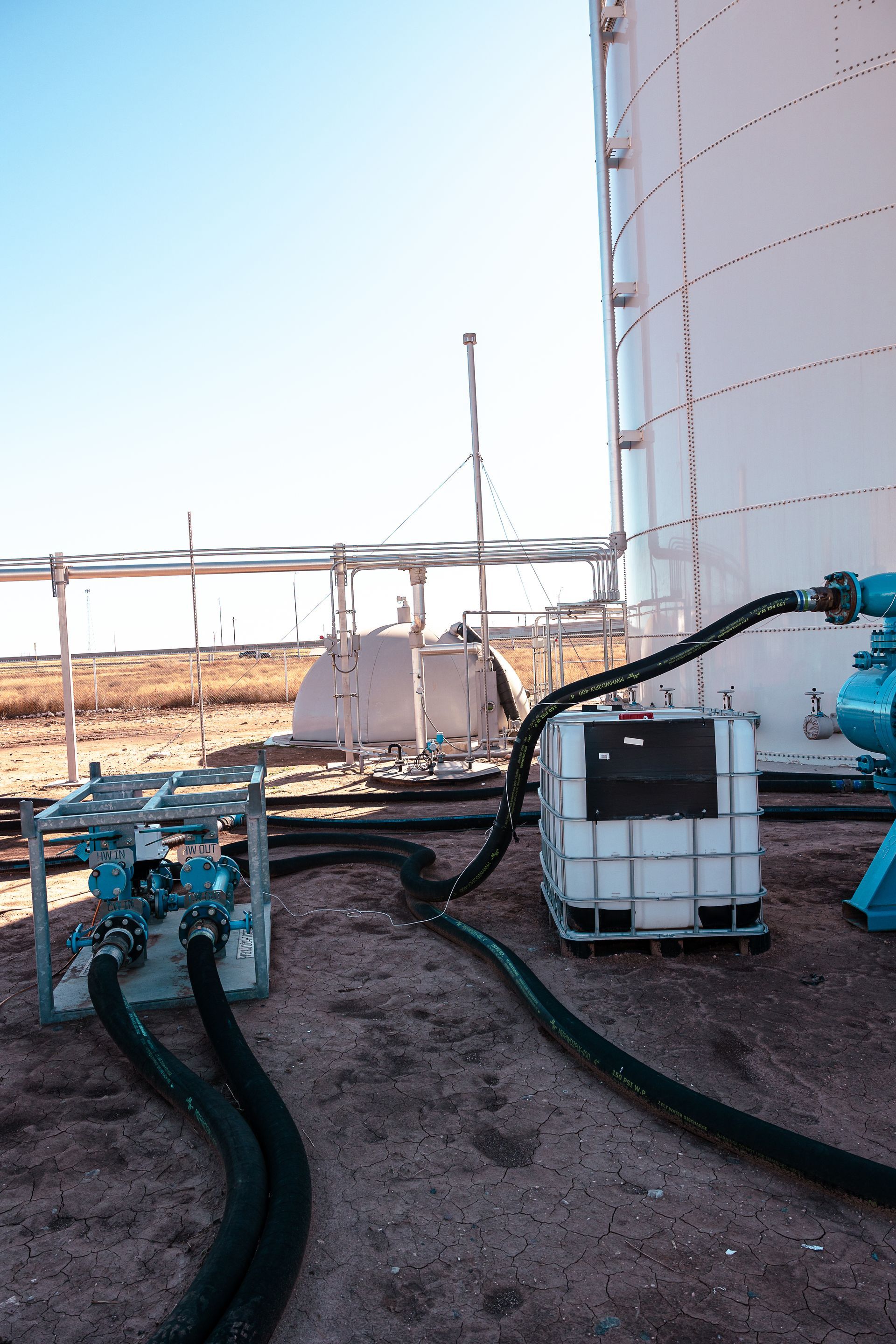 A large white tank is being filled with water.