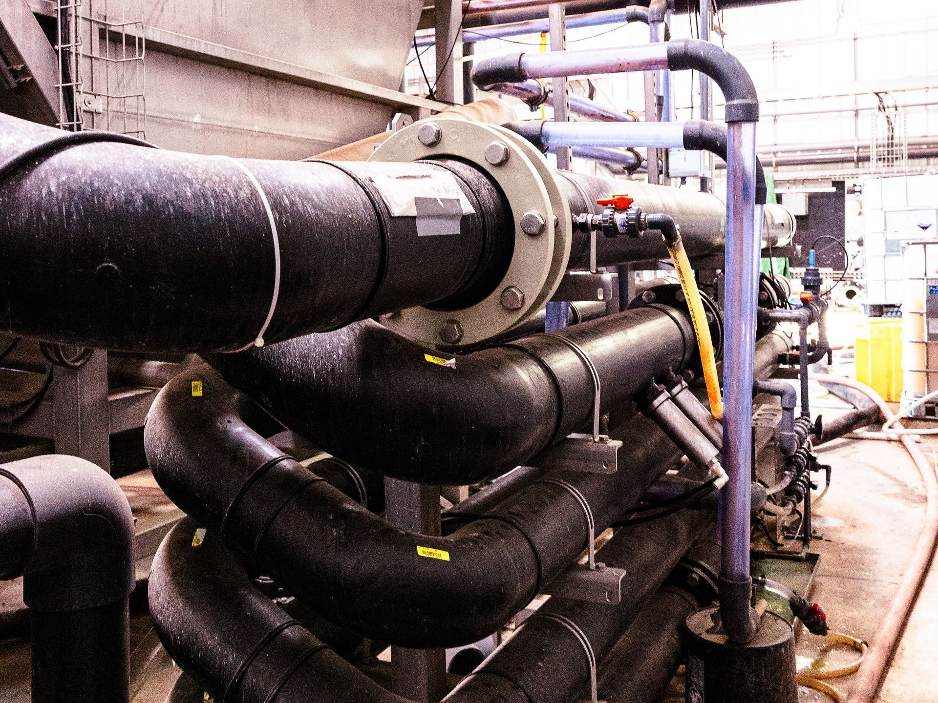 A bunch of pipes are stacked on top of each other in a factory