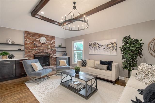 living room staged elegantly with white carpet & hanging chandelier