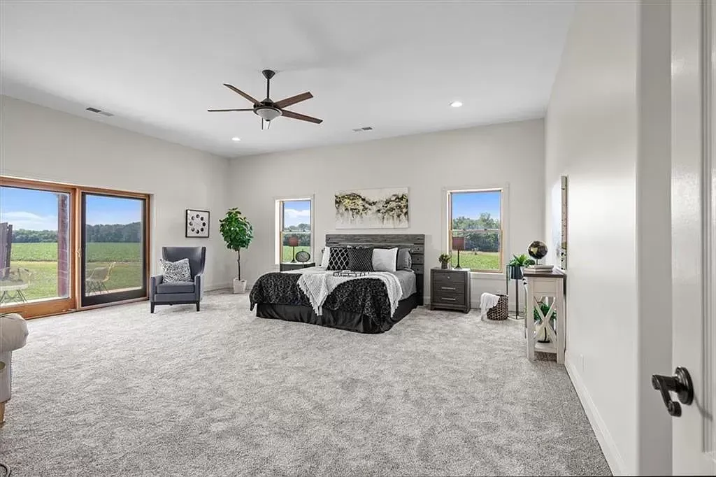 a bedroom with a bed , chair , nightstand and ceiling fan .