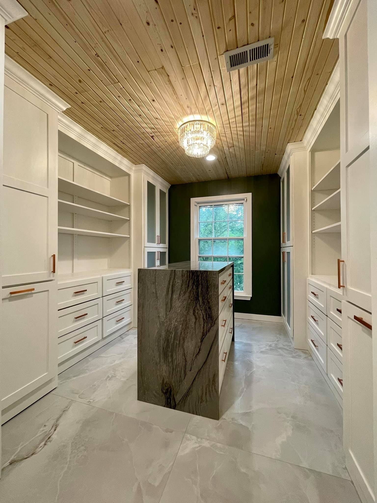 Custom walk-in closet renovation in Shawnee featuring built-in cabinetry, adjustable shelving, and a center island 