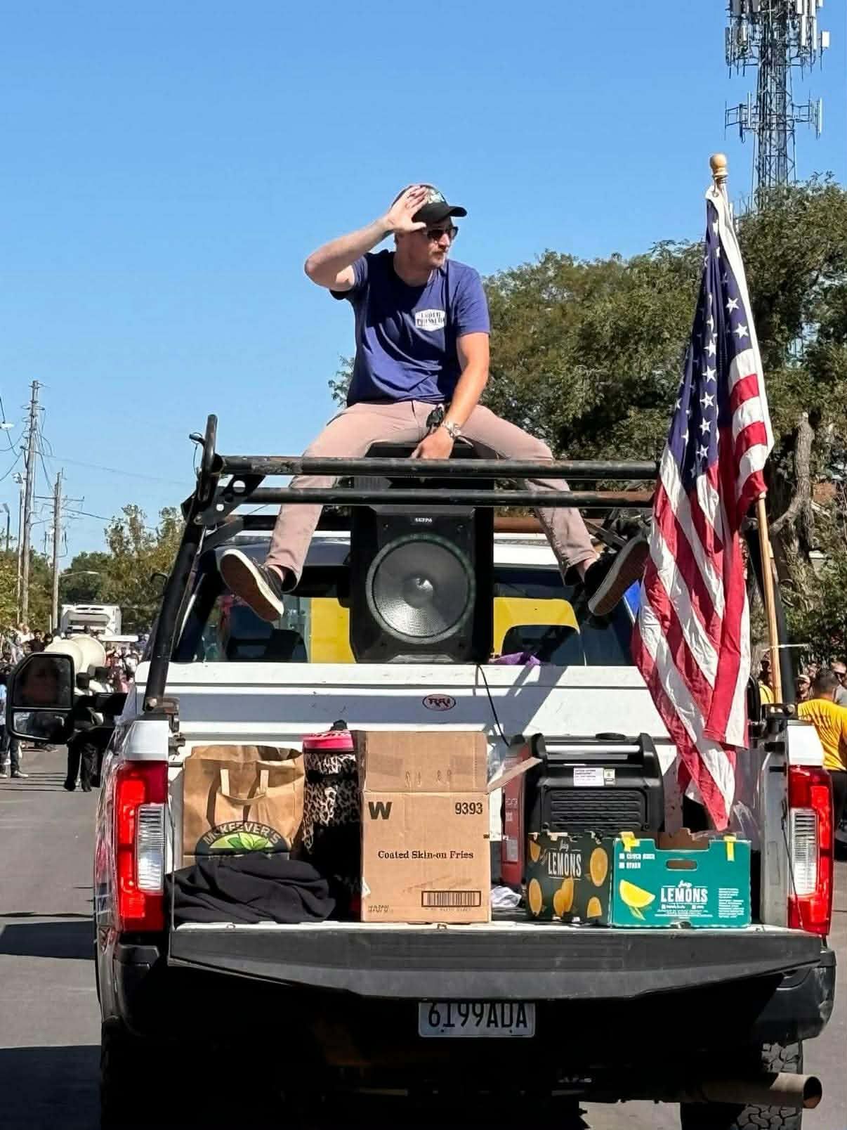 Guy riding on top of a speaker in a parade Kansas City