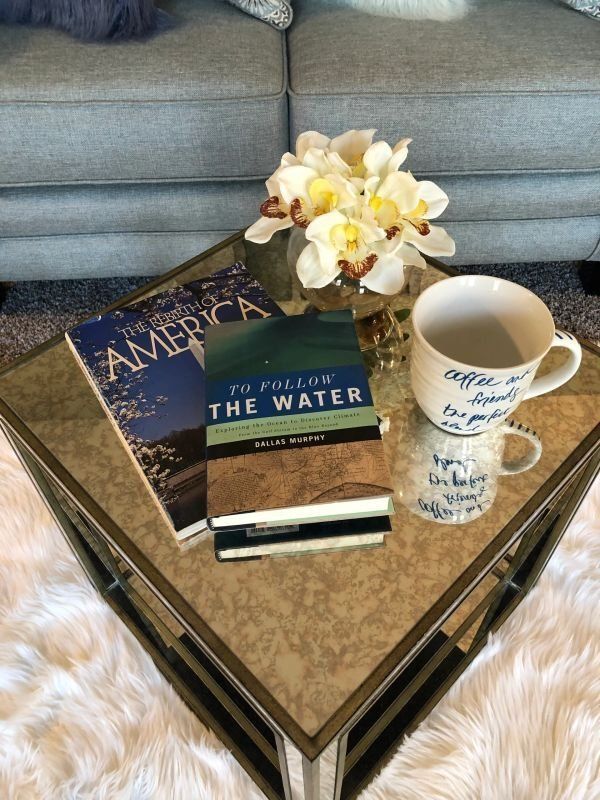 coffee table with magazines and a big cup of joe