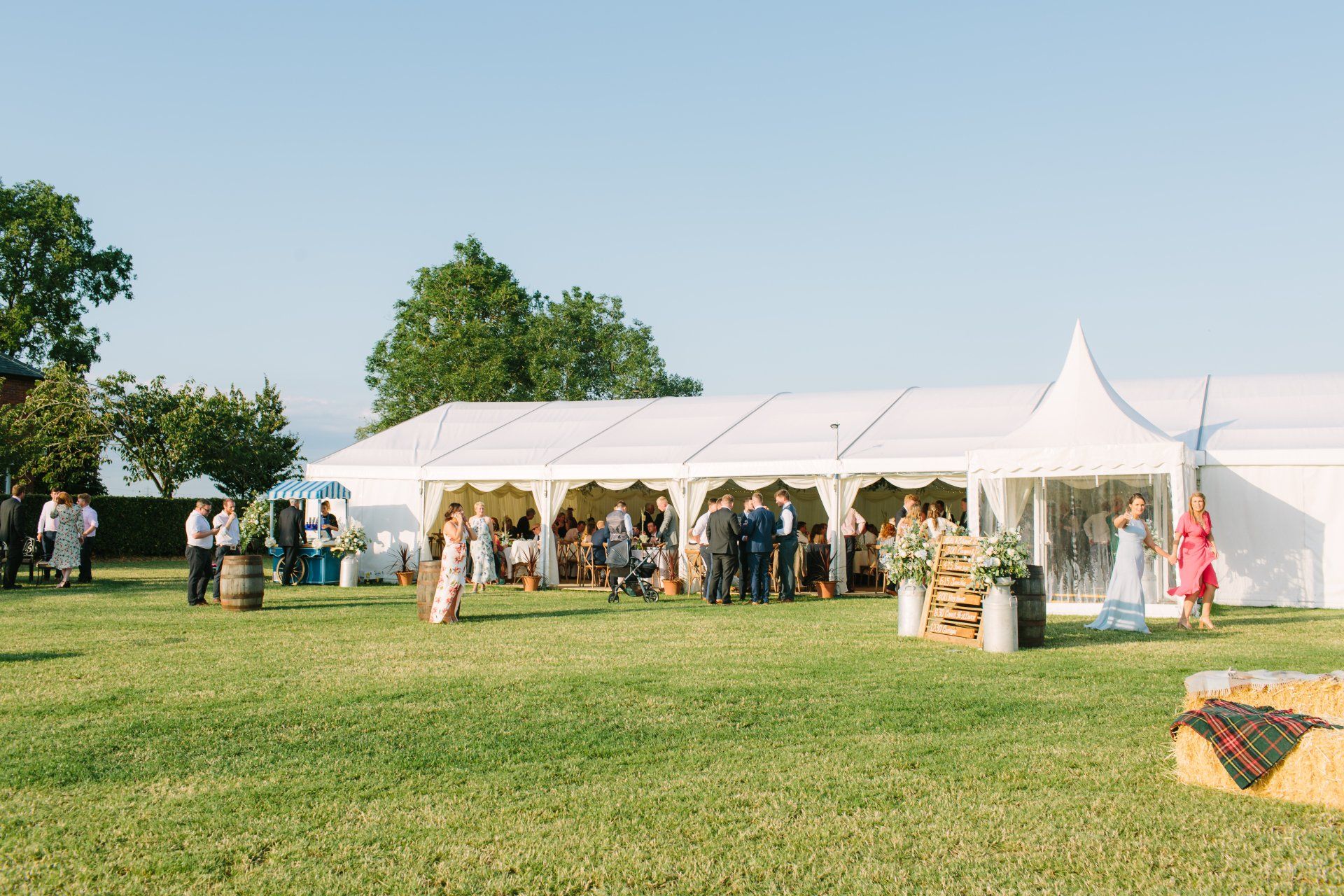 A large white tent is sitting in the middle of a grassy field.