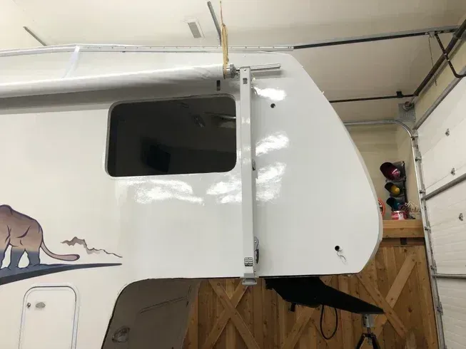 White RV trailer with an open side door in a garage-like space