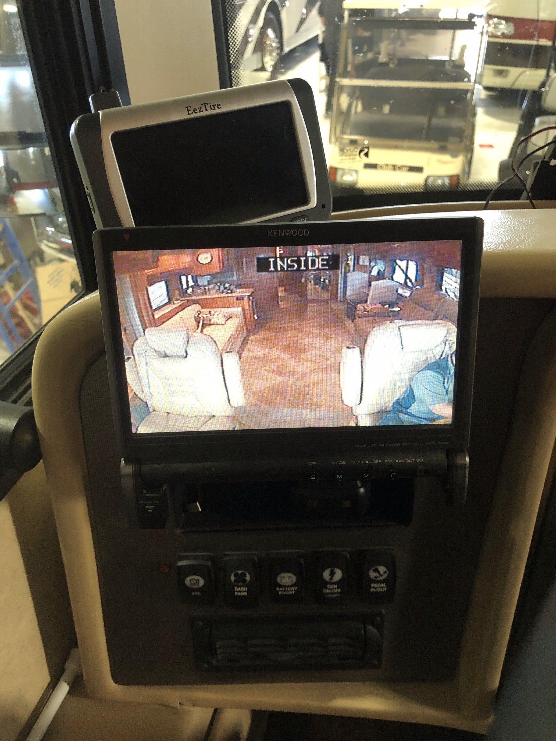 In-car monitor showing a living room on the screen, mounted on a vehicle dashboard.