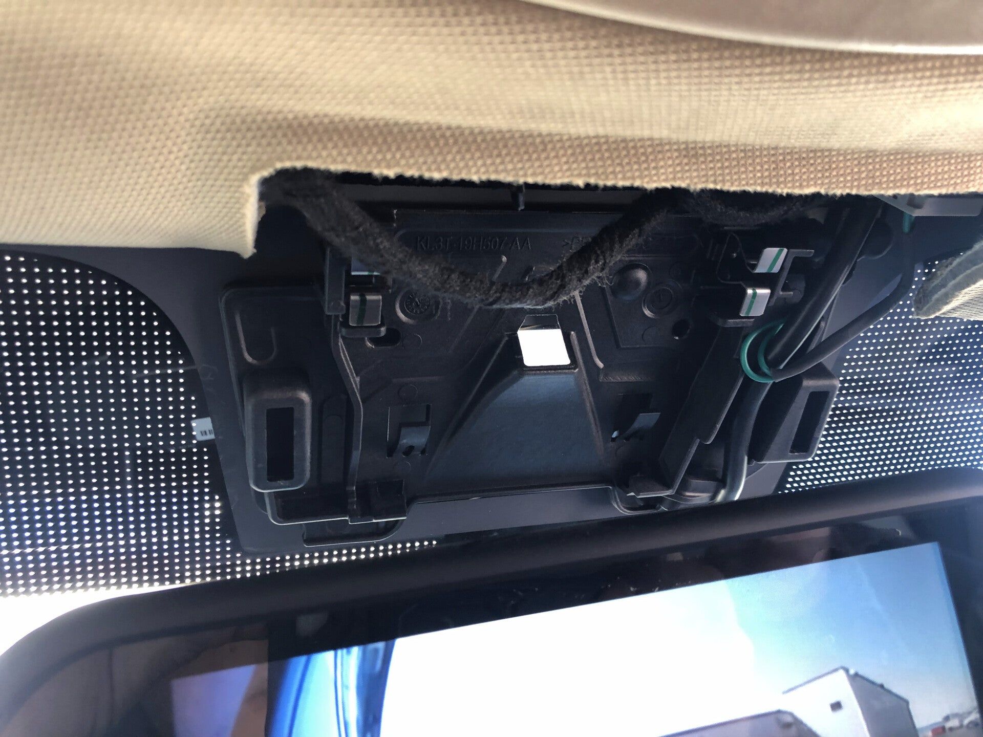Car overhead console panel hanging open, showing exposed wiring near the windshield.