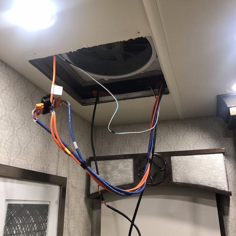 Open ceiling vent with exposed red, blue, and black wires hanging down indoors