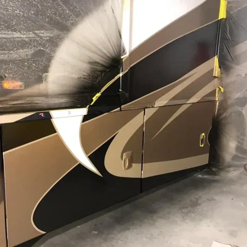 Beige-and-brown RV side panel with a large tear or dent, taped at the top indoors.