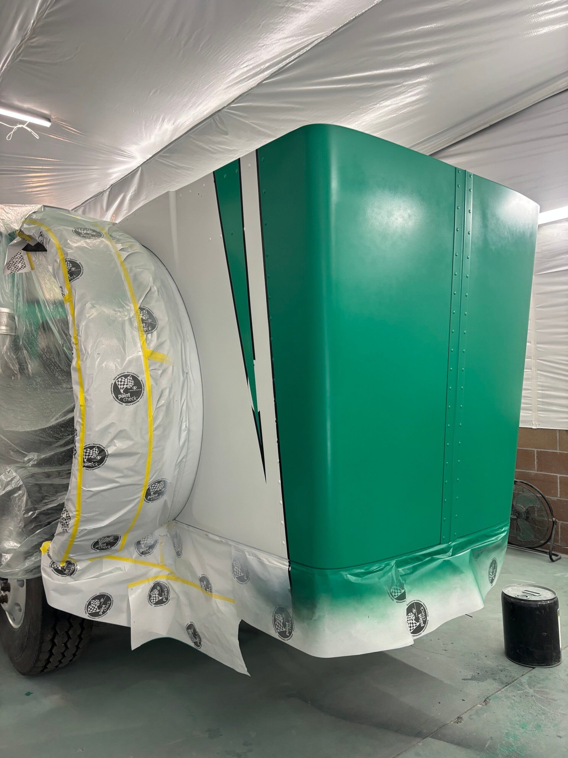 Green HVAC unit under plastic wrap in a ducted mechanical room