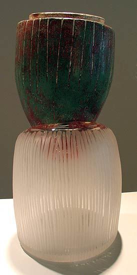 A two-part glass vase, green top, frosted white bottom, banded detail, on a white surface.