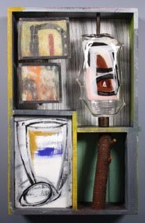 Mixed media artwork in a rectangular frame. Contains geometric shapes and a glass vial, in shades of yellow, blue, and brown.