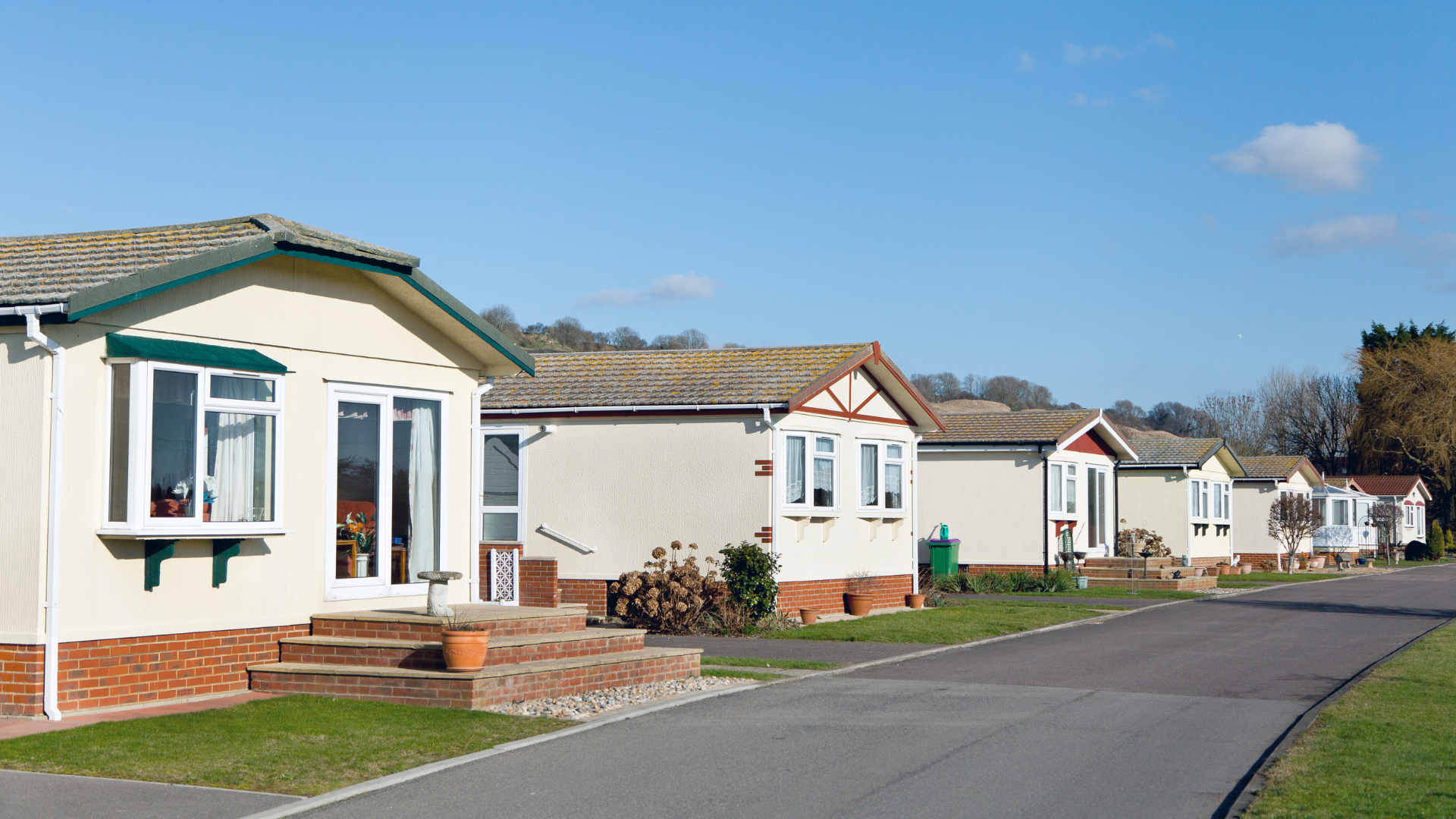 A row of mobile homes are lined up on the side of a road.