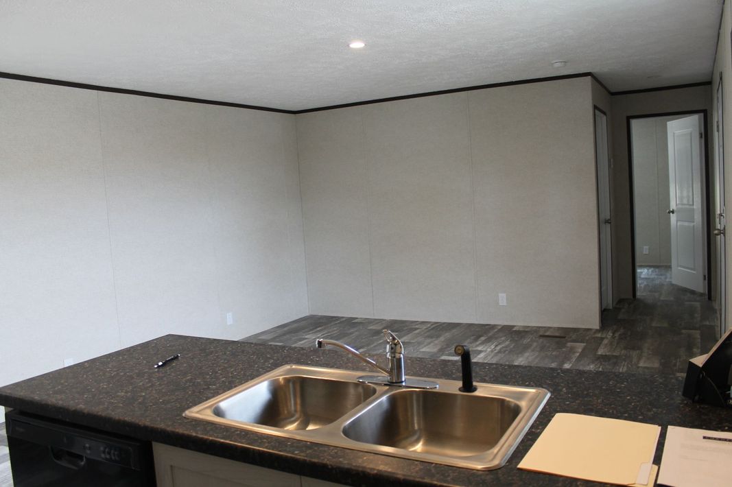 An empty kitchen with a sink and a dishwasher