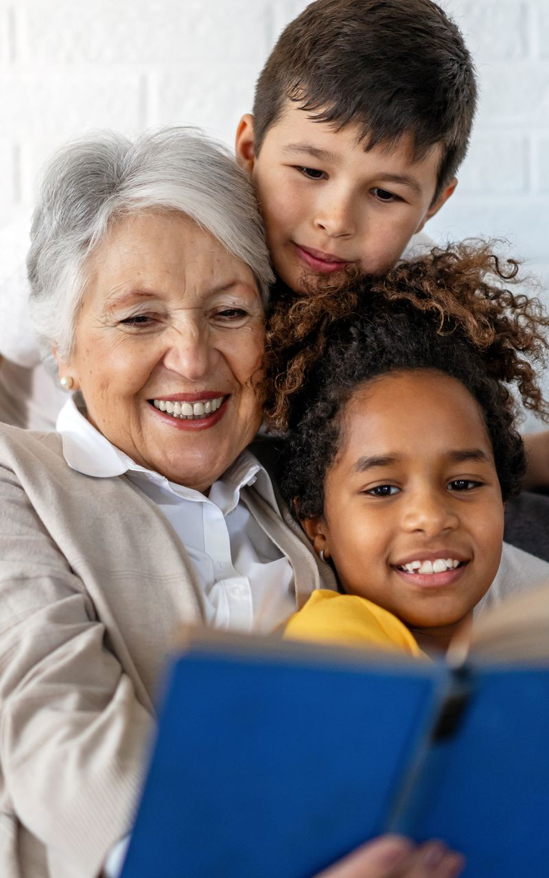 a woman and two young children looking at a book