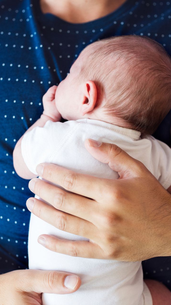 a man and his baby resting on his chest