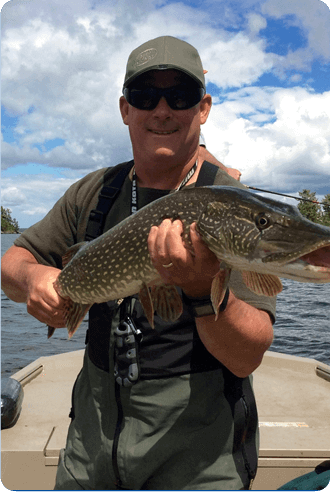 Person on a boat holding a large fish under a cloudy blue sky