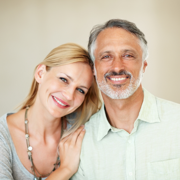 A man and a woman are posing for a picture and smiling