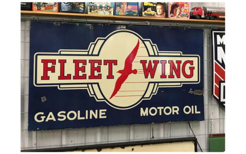Vintage rectangular metal sign for Fleet-Wing gasoline and motor oil, featuring a red bird logo on a cream and blue field.