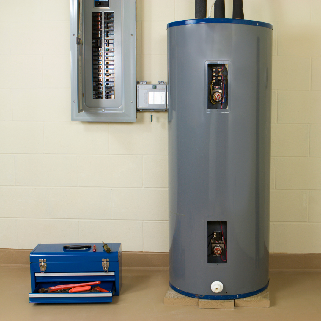 A gray water heater is next to a blue toolbox