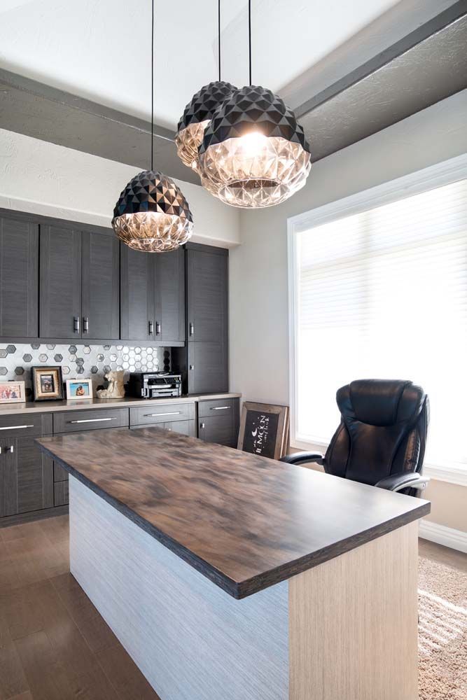 A kitchen with a large island and a chair.
