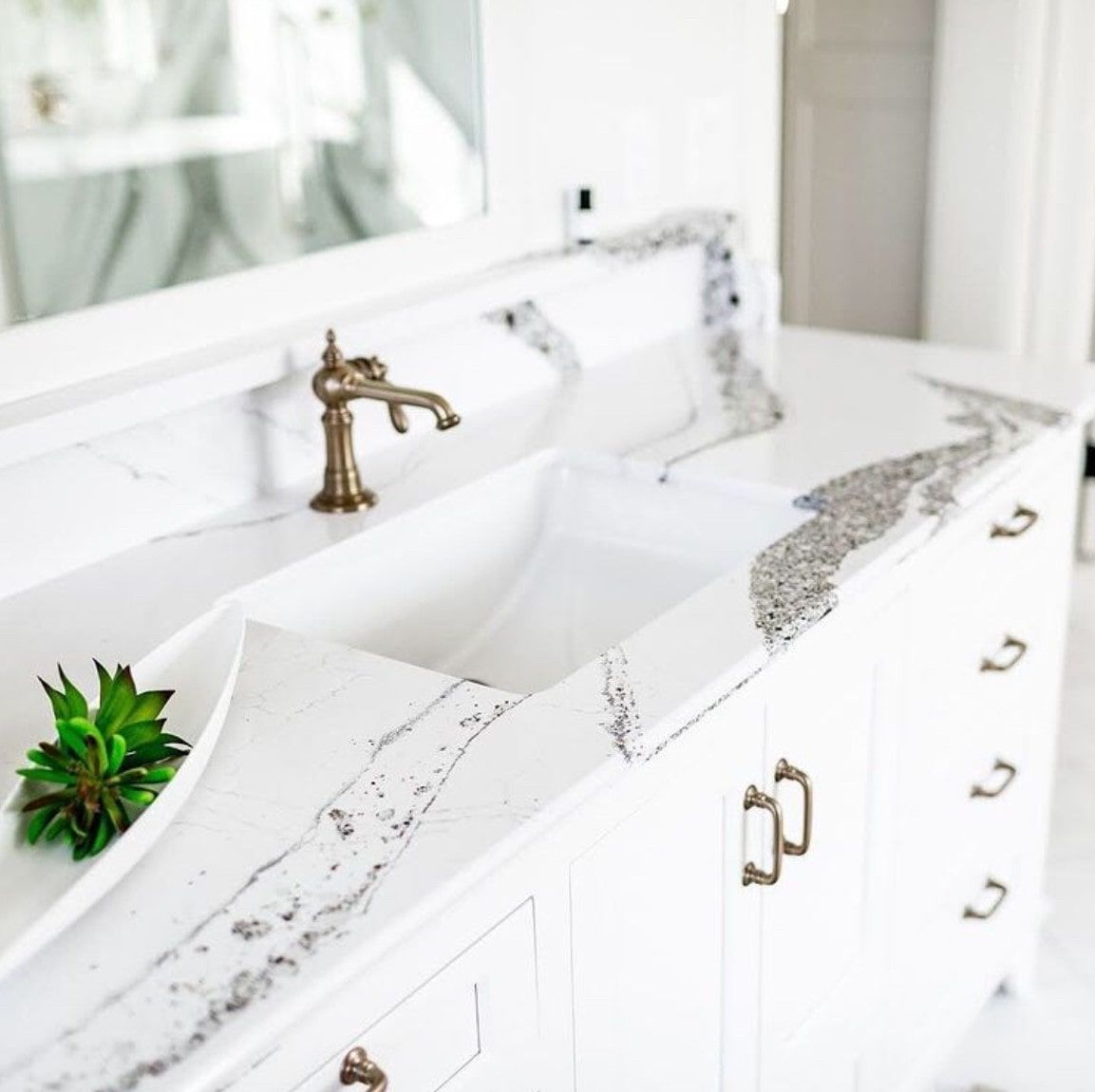 A bathroom sink with a plant on top of it.