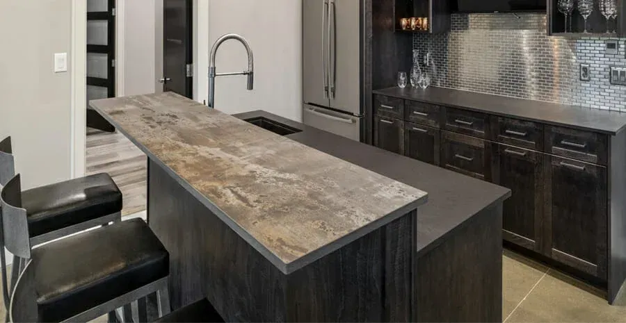 A kitchen with a bar and chairs in it.
