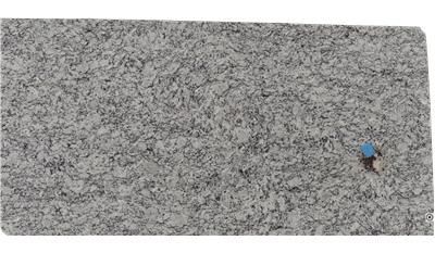 A close up of a piece of granite with a blue object on it.