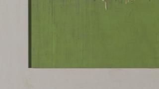 A green painting is hanging on a white wall.