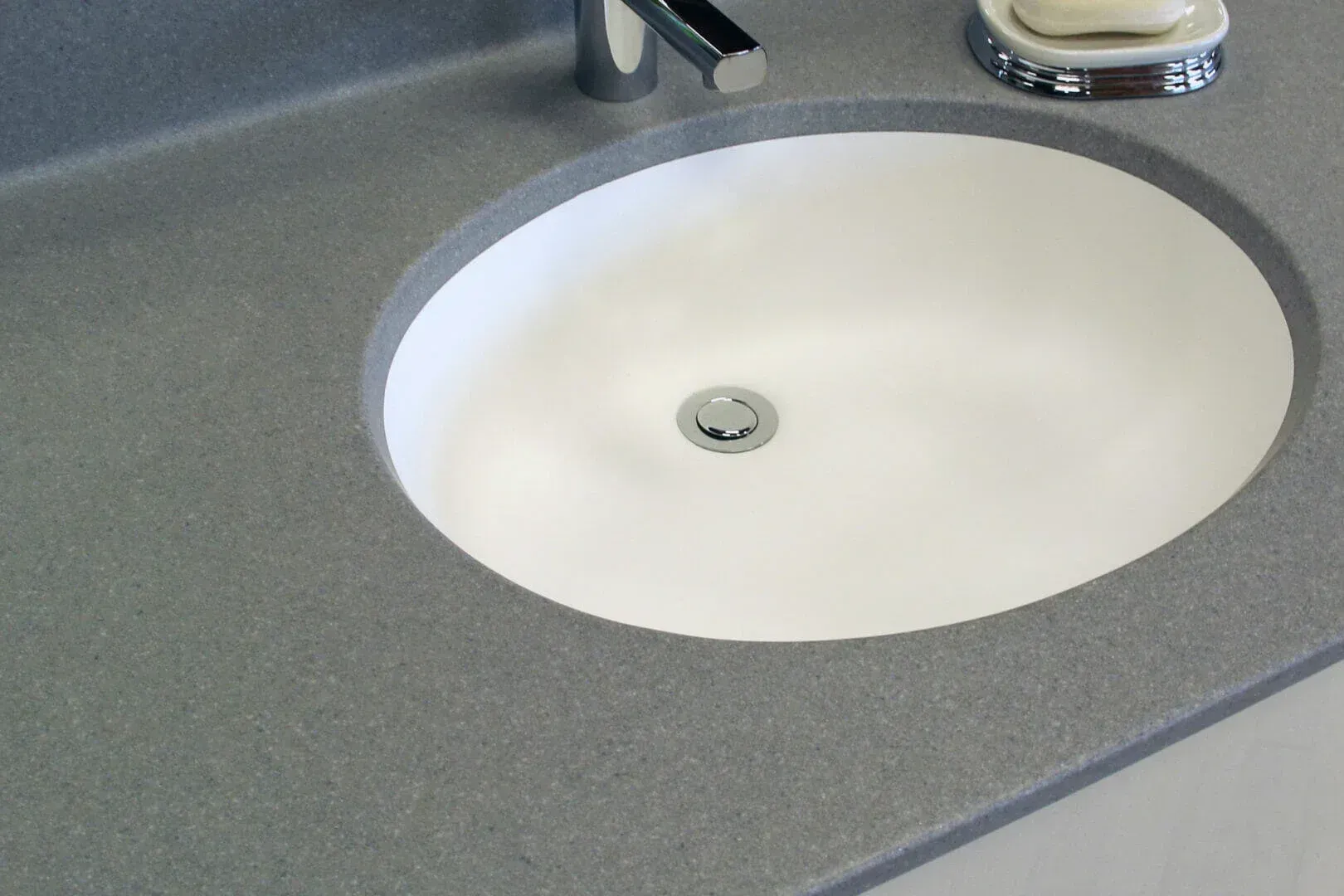 A bathroom sink with a soap dish next to it