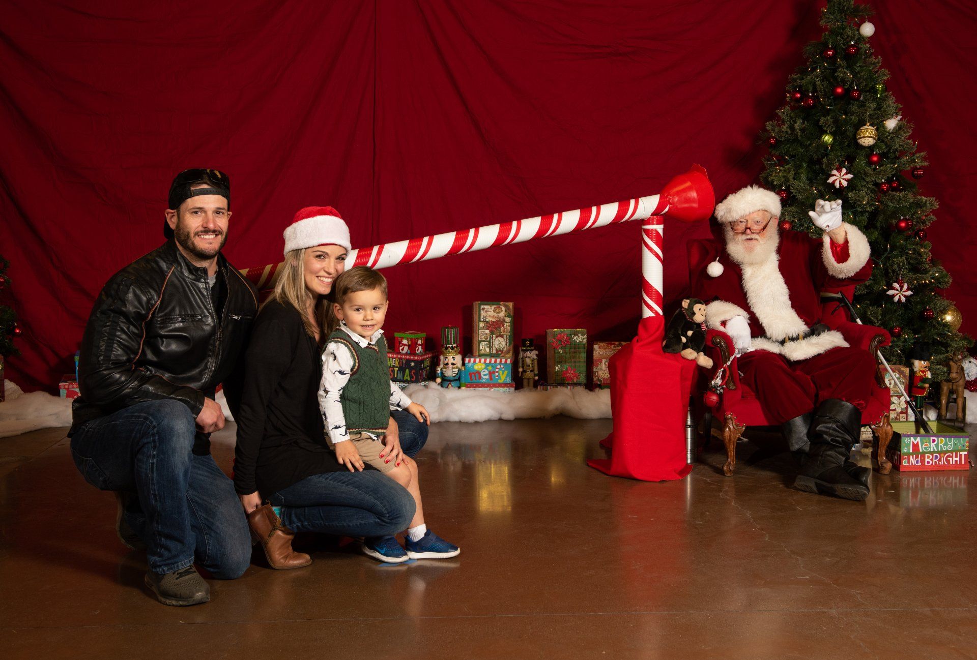 A family is posing for a picture with santa claus in front of a christmas tree.