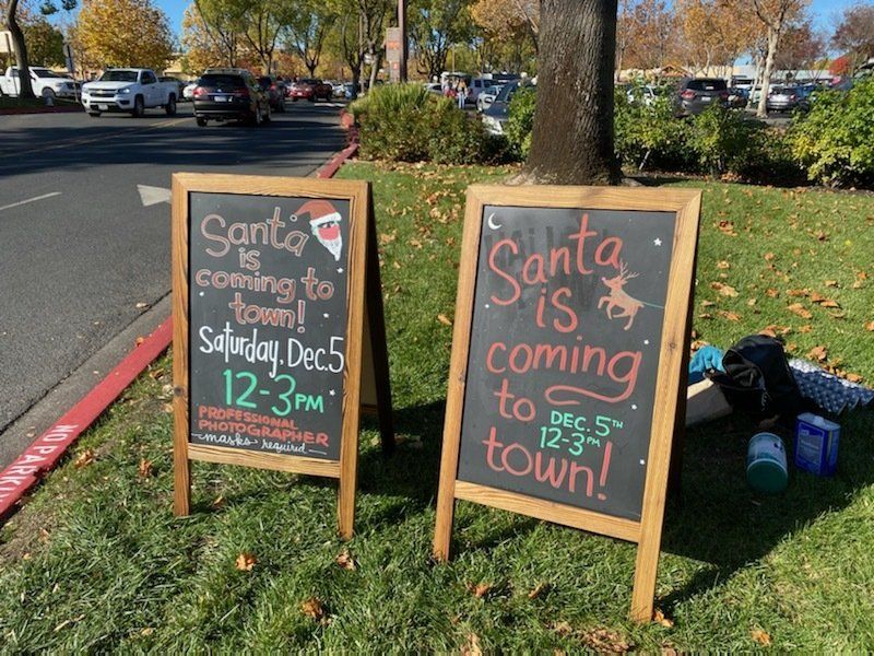 Two chalkboard signs that say santa is coming to town