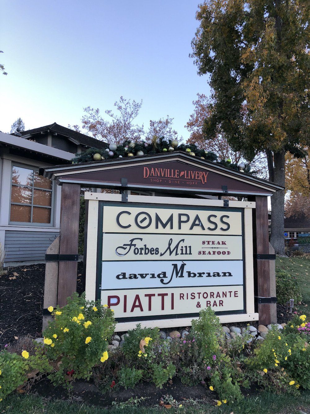 A sign that says compass on it in front of a building