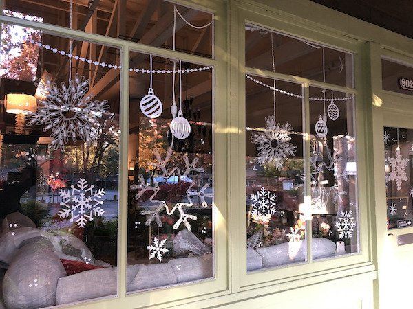 A store front with christmas decorations on the windows.