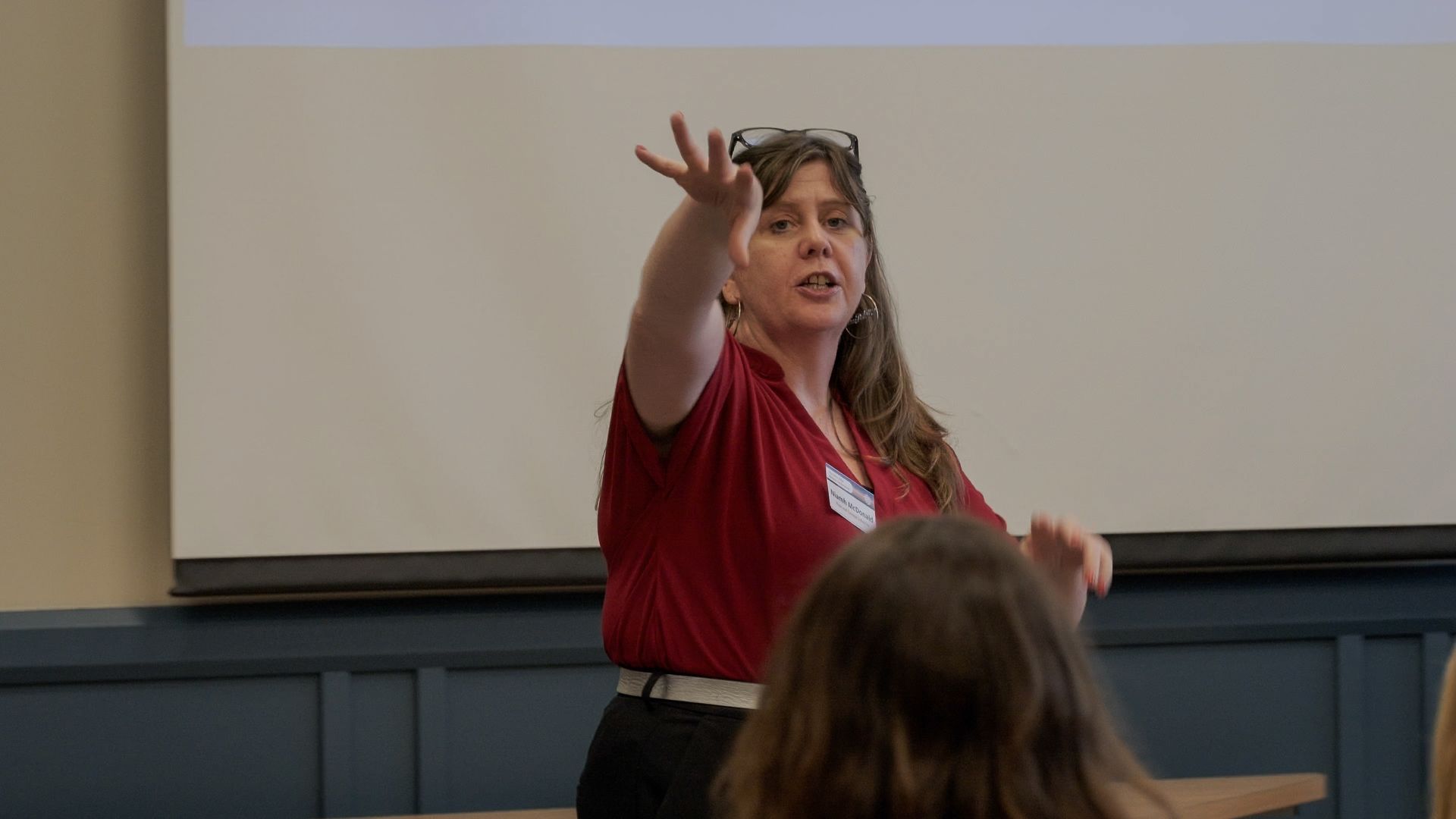 a woman stands at a podium speaking into a microphone