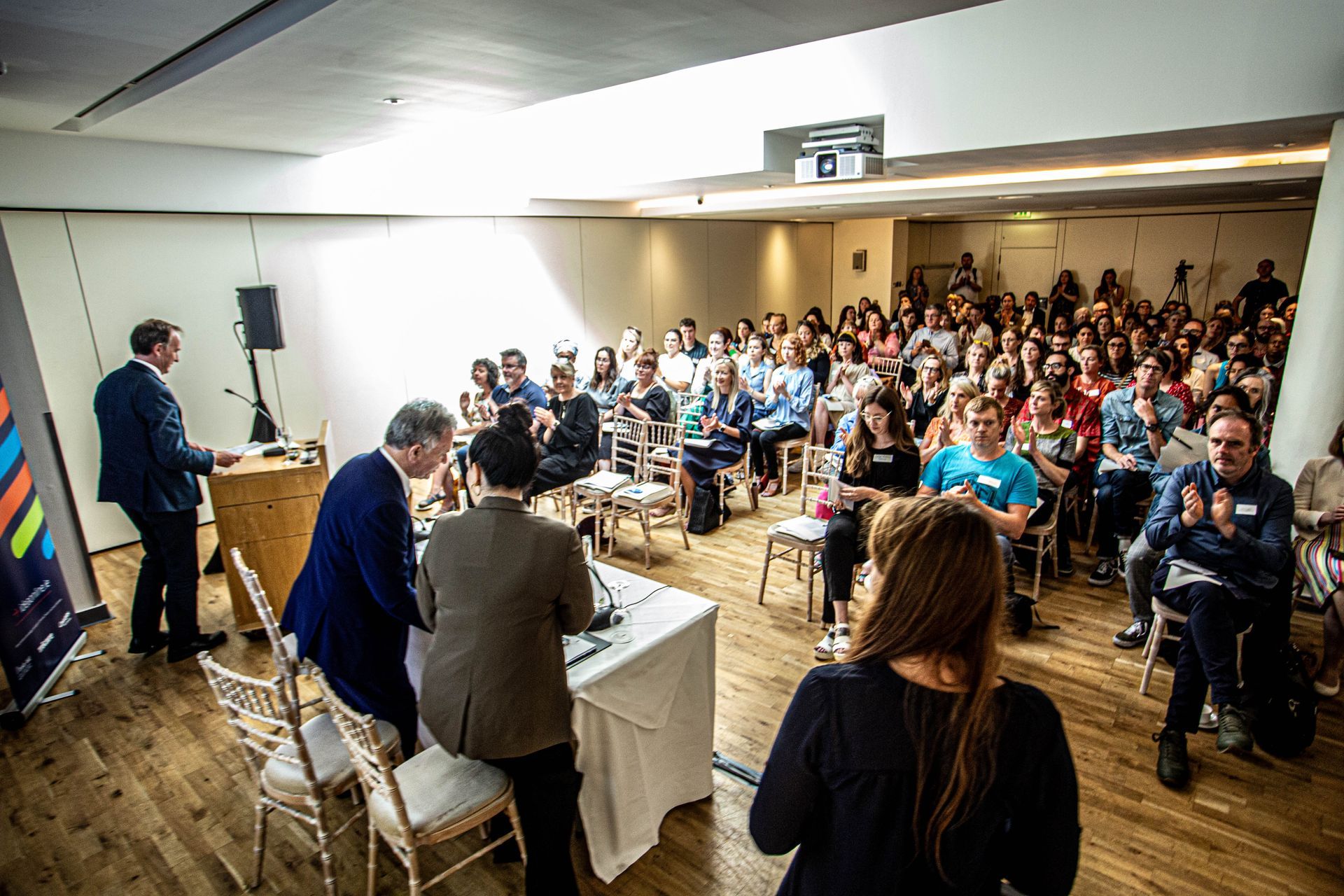 a man is giving a presentation in front of a large crowd