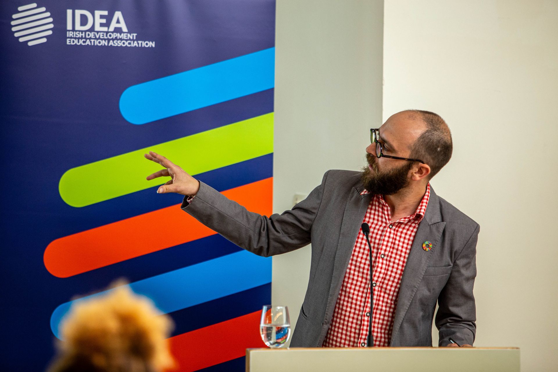 a man giving a presentation in front of a sign that says idea