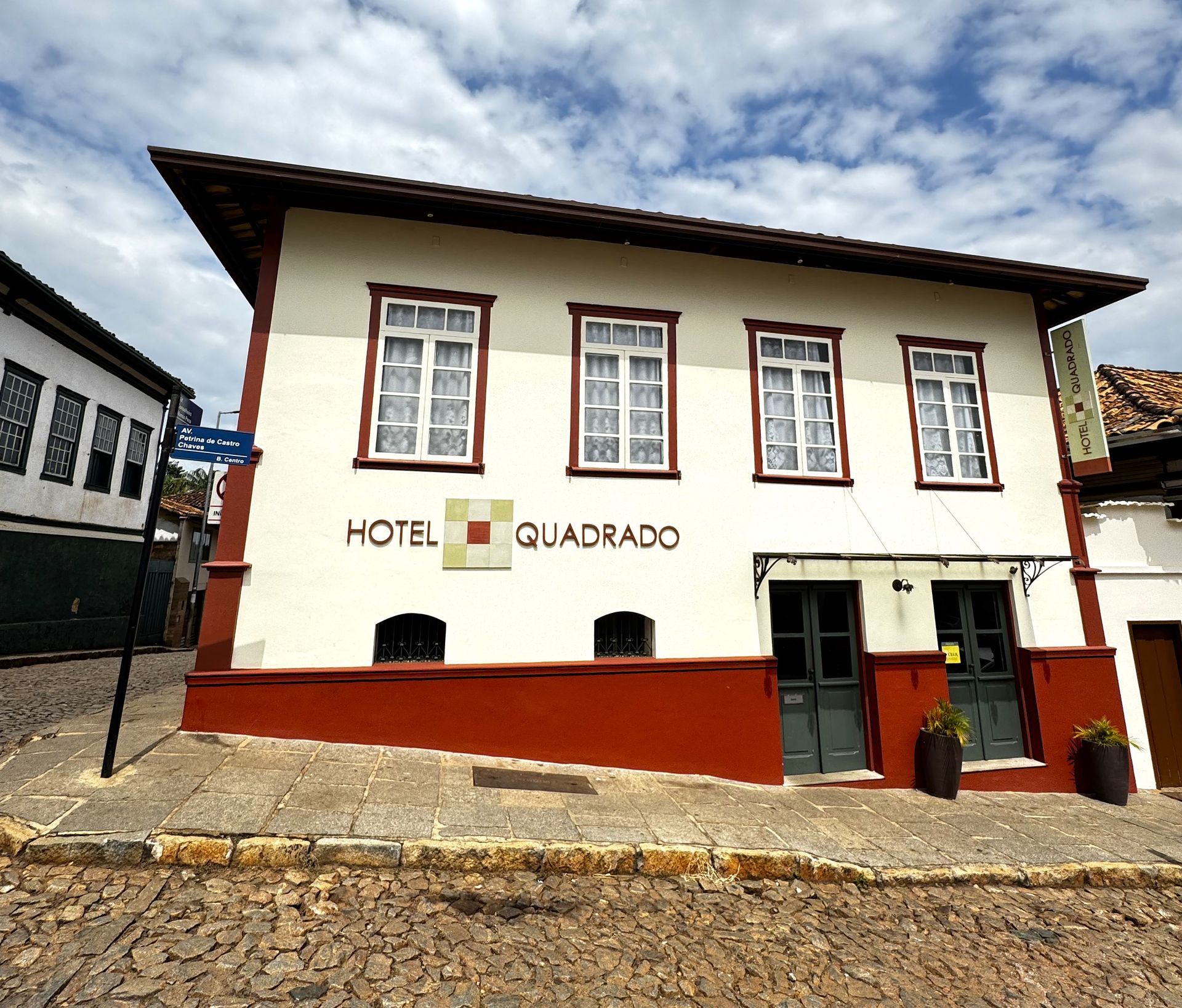 Um prédio branco com a palavra hotel nele. Hotel Quadrado