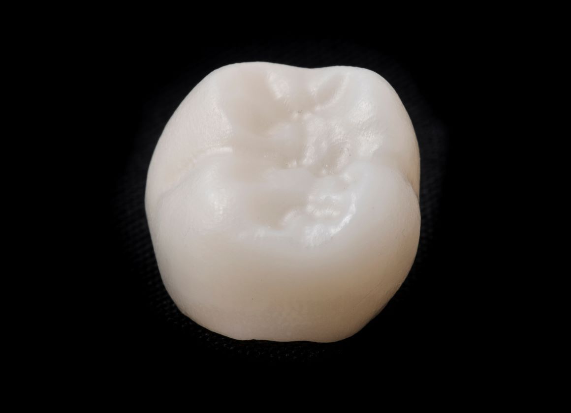 A close up of a white tooth on a black background