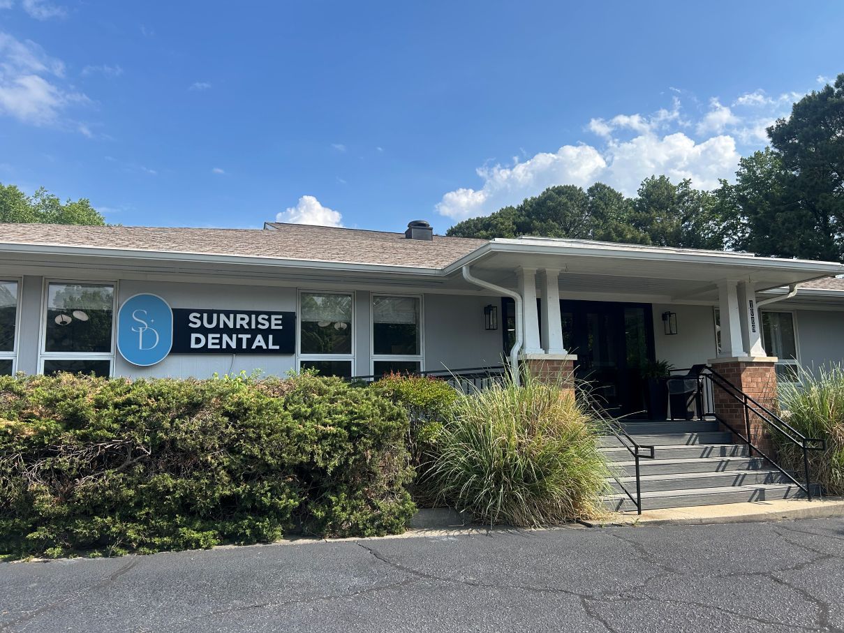 Sunrise Dental storefront with white awning, blue sign, and steps leading to the entrance in Raleigh NC