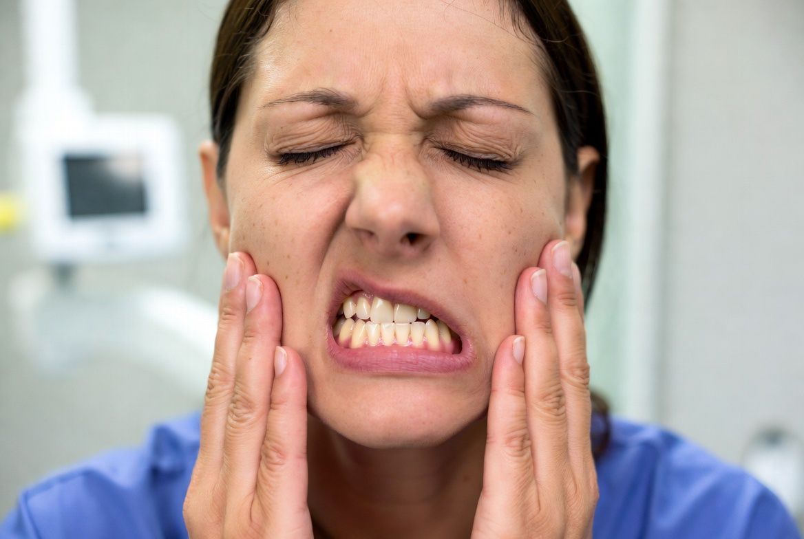 A man is sitting in a dental chair talking to a dentist in Raleigh, NC.