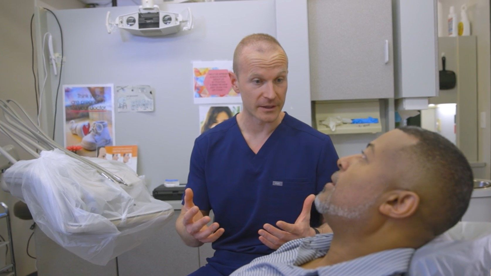 A man is sitting in a dental chair talking to a dentist near Wake Forest, NC.